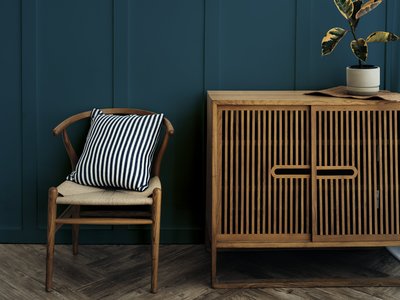 scandinavian-vintage-wood-cabinet-with-chair-by-dark-blue-wall